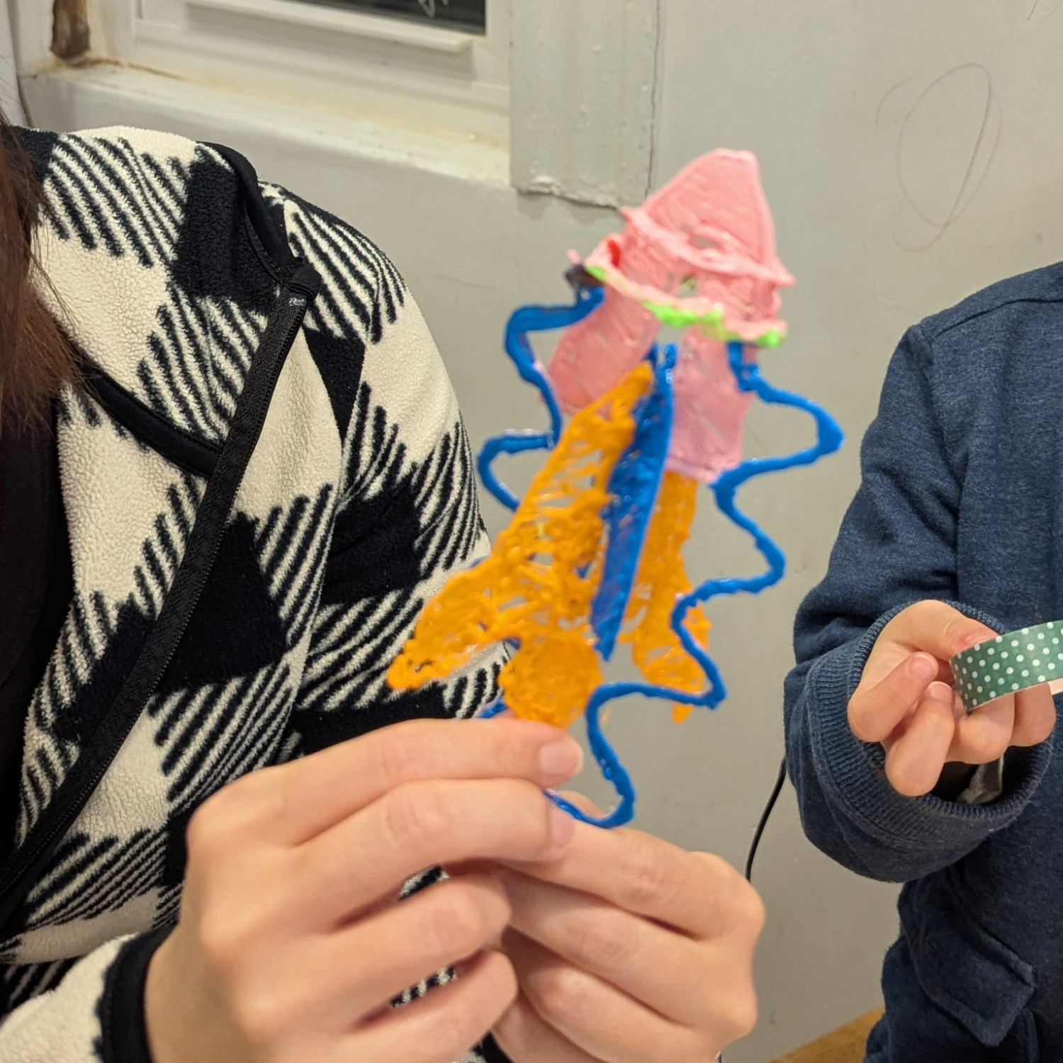 Child holding a completed 3D pen rocket — hands-on STEAM kit project by Enki Atelier